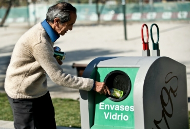 Un hombre coloca una botella en un tacho de reciclaje de vidrio en Santiago el 12 de junio de 2013. Foto: AFP. reciclaje chile ley