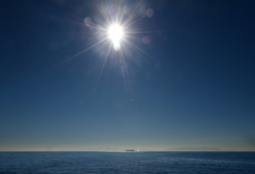 Un buque de carga se divisa bajo el sol en el horizonte en el Océano Pacífico a pocos kilómetros de la costa de Long Beach, California el 12 de enero de 2016. Foto: AFP. tempertaturas récord mundo