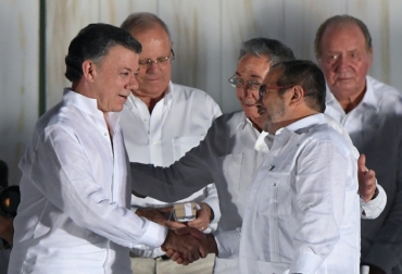 El presidente cubano, Raúl Castro, saluda a su homólogo colombiano, Juan Manuel Santos (i), y al líder de las FARC, Rodrigo Londoño ('Timochenko'), tras la firma del acuerdo de paz el 26 de septiembre de 2016 en Cartagena, Colombia. Foto: AFP. paz santos farc colombia